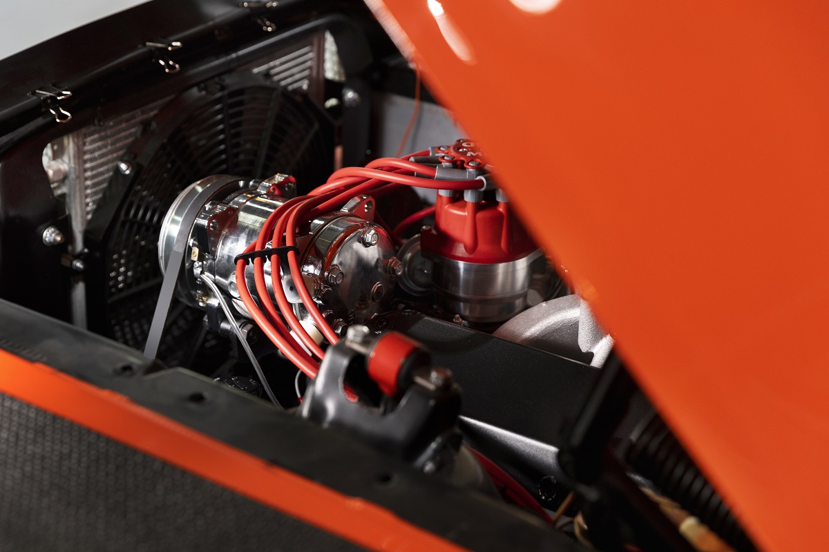 red car with its hood half open, exposing the engine