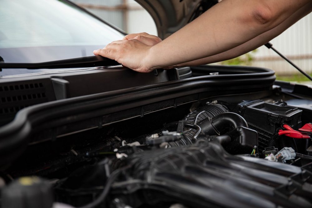 close-up of a man checking a car's engine