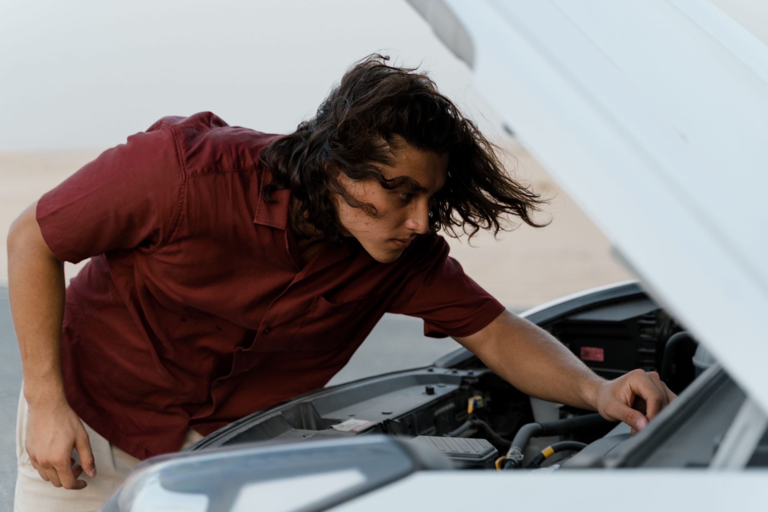 man checking a car's engine